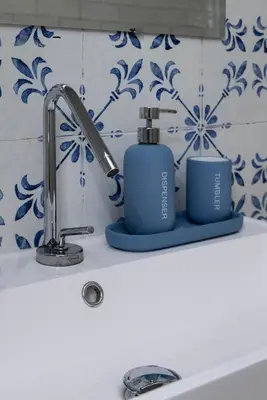 a sink with a faucet and two bottles of soap at Casetta Bianca Luxury in Santa Flavia