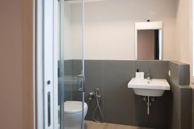 a bathroom with a toilet and a sink and a shower at Bivio 281 suite&rooms in Carini