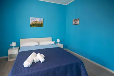 a blue bedroom with a bed with two towels at Bivio 281 suite&rooms in Carini
