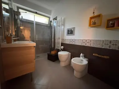 a bathroom with two toilets and a sink and a shower at Amunì Guest House in Carini