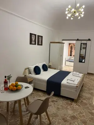 a bedroom with a bed and a table and chairs at Appartamenti Tiffany & Timi in Carini