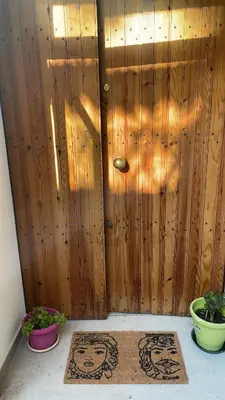 a wooden wall with two rugs in front of a door at Al Duomo apartment in Palermo in Palermo