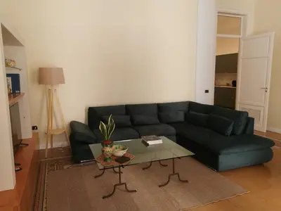 a living room with a black couch and a table at Le case di Giù in Palermo