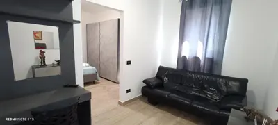 a black leather couch in a living room with a mirror at Ottolune Accomodations in Campofelice di Roccella