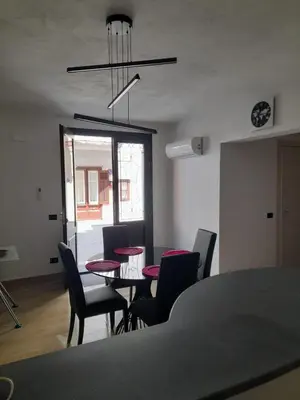 a dining room with a table and chairs and a chandelier at Ottolune Accomodations in Campofelice di Roccella