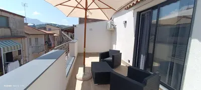 a balcony with an umbrella on a building at Ottolune Accomodations in Campofelice di Roccella
