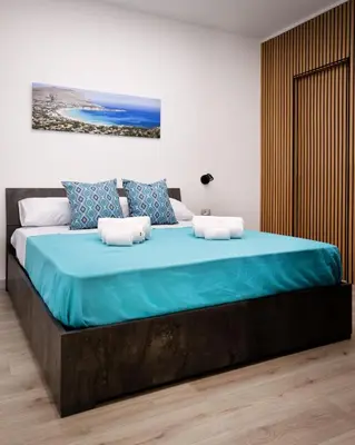 a bedroom with a large bed with blue sheets at Matrice Rooms in Palermo