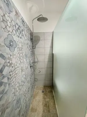 a bathroom with a shower with a tile wall at Matrice Rooms in Palermo