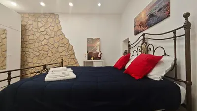 a bedroom with a black bed with red pillows at Casuzza del genio in Palermo