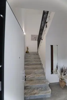 a staircase in a house with white walls and wooden floors at Twins House Vacation Home in Carini
