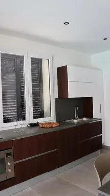 a kitchen with a counter with a sink and two windows at Villa Zagara modern villa with pool in Lascari