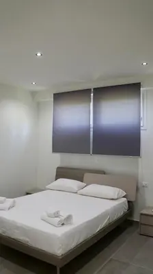 a bedroom with a large bed with white sheets at Villa Zagara modern villa with pool in Lascari