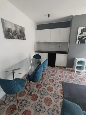 a living room with a glass table and blue chairs at Vento di Sicilia in Carini