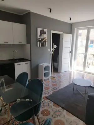 a living room with a table and chairs and a kitchen at Vento di Sicilia in Carini