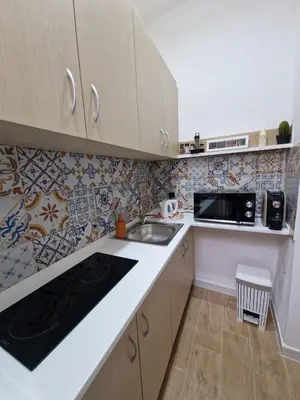 a small kitchen with a sink and a microwave at Da poppa a prua in Palermo