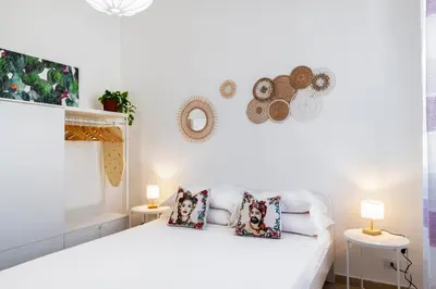 a white bedroom with a white bed with pillows at Casa del Saraceno in Palermo