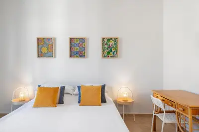 a bedroom with a bed and three paintings on the wall at Casa del Saraceno in Palermo
