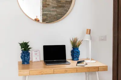a desk with a laptop and two blue vases at Casa del Saraceno in Palermo