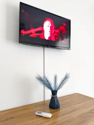 a television on a wall with a vase on a table at Casa Nonna Pina in Palermo