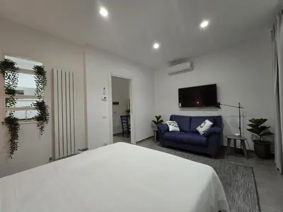 a bedroom with a bed and a blue couch at Domus Minerva in Palermo