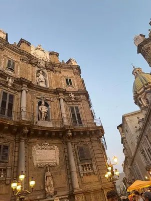 a building with a statue on the side of it at santa Rosalia home in Palermo