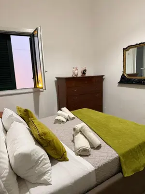 a bedroom with a bed with towels and a mirror at santa Rosalia home in Palermo