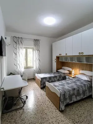 a hotel room with two beds and a desk at Casa Hyccarina in Carini