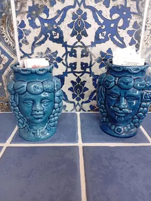 two blue vases are sitting on a tile floor at lia&gio' in Campofelice di Roccella