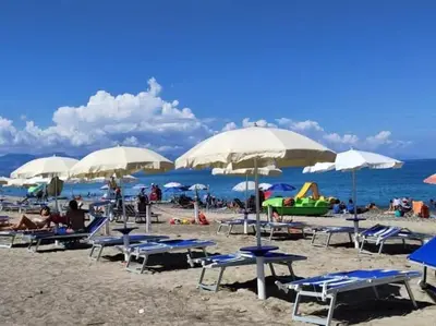 a beach with chairs and umbrellas and people on it at lia&gio' in Campofelice di Roccella