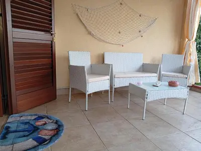 a patio with chairs and a table and a net at lia&gio' in Campofelice di Roccella