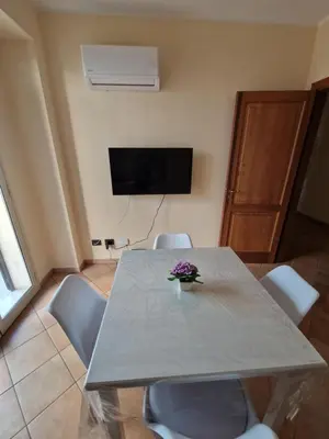 a dining room table with chairs and a television at Sicily's Garden in Bagheria