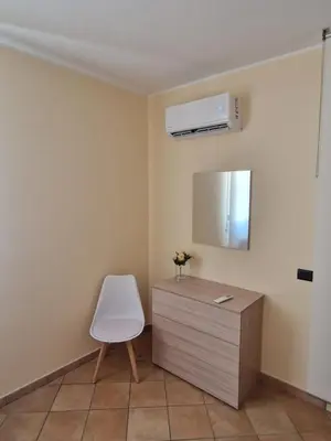 a room with a chair and a dresser with a mirror at Sicily's Garden in Bagheria