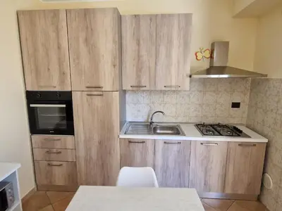 a small kitchen with wooden cabinets and a sink at Sicily's Garden in Bagheria