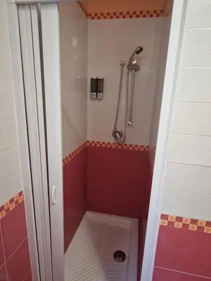 a bathroom with a shower with red tile at Sicily's Garden in Bagheria