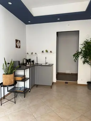 a room with a kitchen with a sink and a table at Magione House Rooms in Palermo