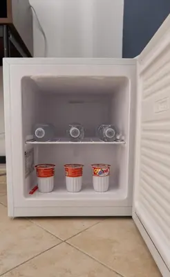 an open refrigerator door with four cups in it at Magione House Rooms in Palermo