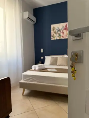 a bedroom with a bed with a blue wall at Magione House Rooms in Palermo