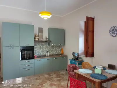 a kitchen with blue cabinets and a table with chairs at Il Gelsomino in Bagheria