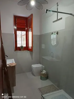 a white bathroom with a toilet and a sink at Il Gelsomino in Bagheria