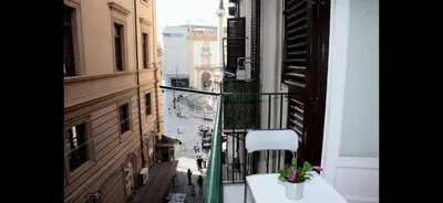 a balcony with a table and a view of a street at Casa vucciria in Palermo