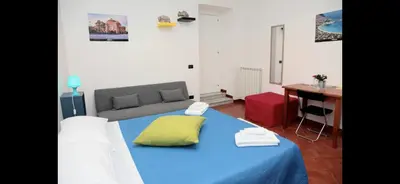 a room with a bed and a desk and a table at Casa vucciria in Palermo