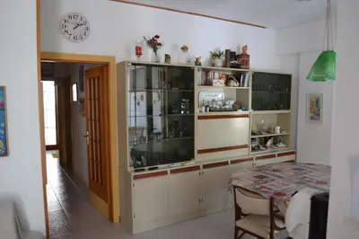 a dining room with a table and a glass cabinet at Villa Eugenia - Mondello Beach in Palermo