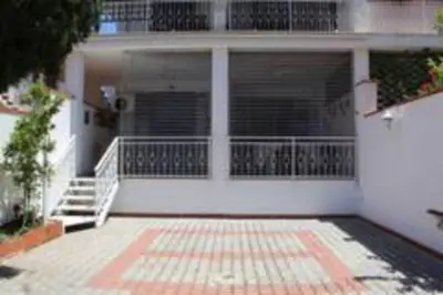 a white house with a porch and a balcony at Villa Eugenia - Mondello Beach in Palermo