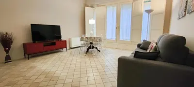 a living room with a flat screen tv and a couch at Dimora Artale Suite in Palermo