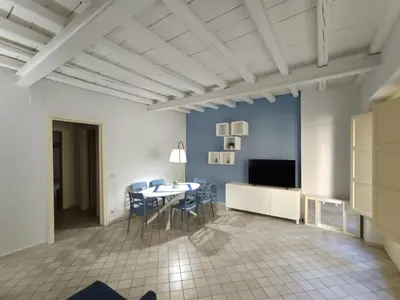 a living room with a table and chairs and a tv at Dimora Artale Suite in Palermo