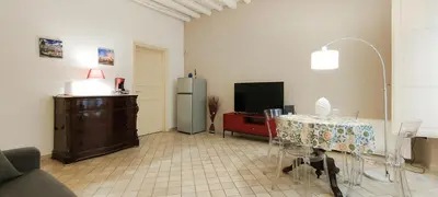 a living room with a table and a tv at Dimora Artale Suite in Palermo