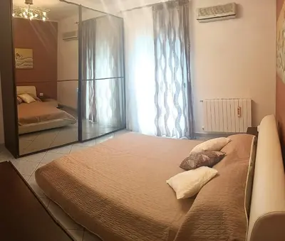 a bedroom with a large bed and a mirror at Appartamento vista mare in Castellammare del Golfo