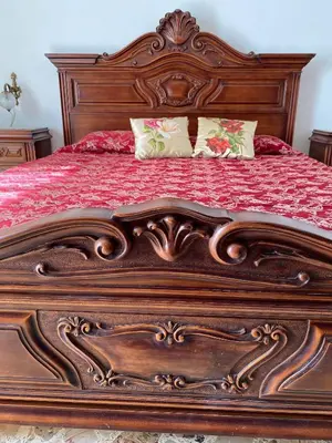 a wooden bed with a wooden frame with pillows on it at Charming Historic Villa in Vita, Sicily - Your Home Away from Home in Vita