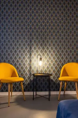 a room with two chairs and a table with a lamp at Finestre sul Massimo - Centro Storico Palermo in Palermo