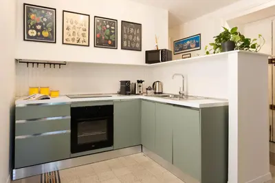 a kitchen with green cabinets and a sink at Finestre sul Massimo - Centro Storico Palermo in Palermo